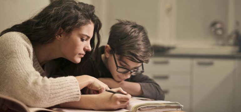 personne aidant un enfant dans ses devoirs